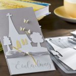 Ideen für Kommunion und Konfirmation: Komm zur Kirche | Einladung in Taupe und Weiß mit der Silhouette einer Kirche, zartgelben Schmetterlingen und einem schwungvollen Schriftzug