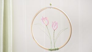 Ideen für Papierdraht: Tulpen | Tulpen aus Papierdraht in Pink und Orange mit grünen Blättern in einem Holzring zum Aufhängen