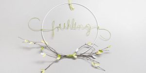 Ideen für den Frühling: Hula Hoop für die Deko zuhause | Metallring mit Papierdraht, Zweig und ausgestanzten Blättern in hellem Grün, Gelb und Weiß
