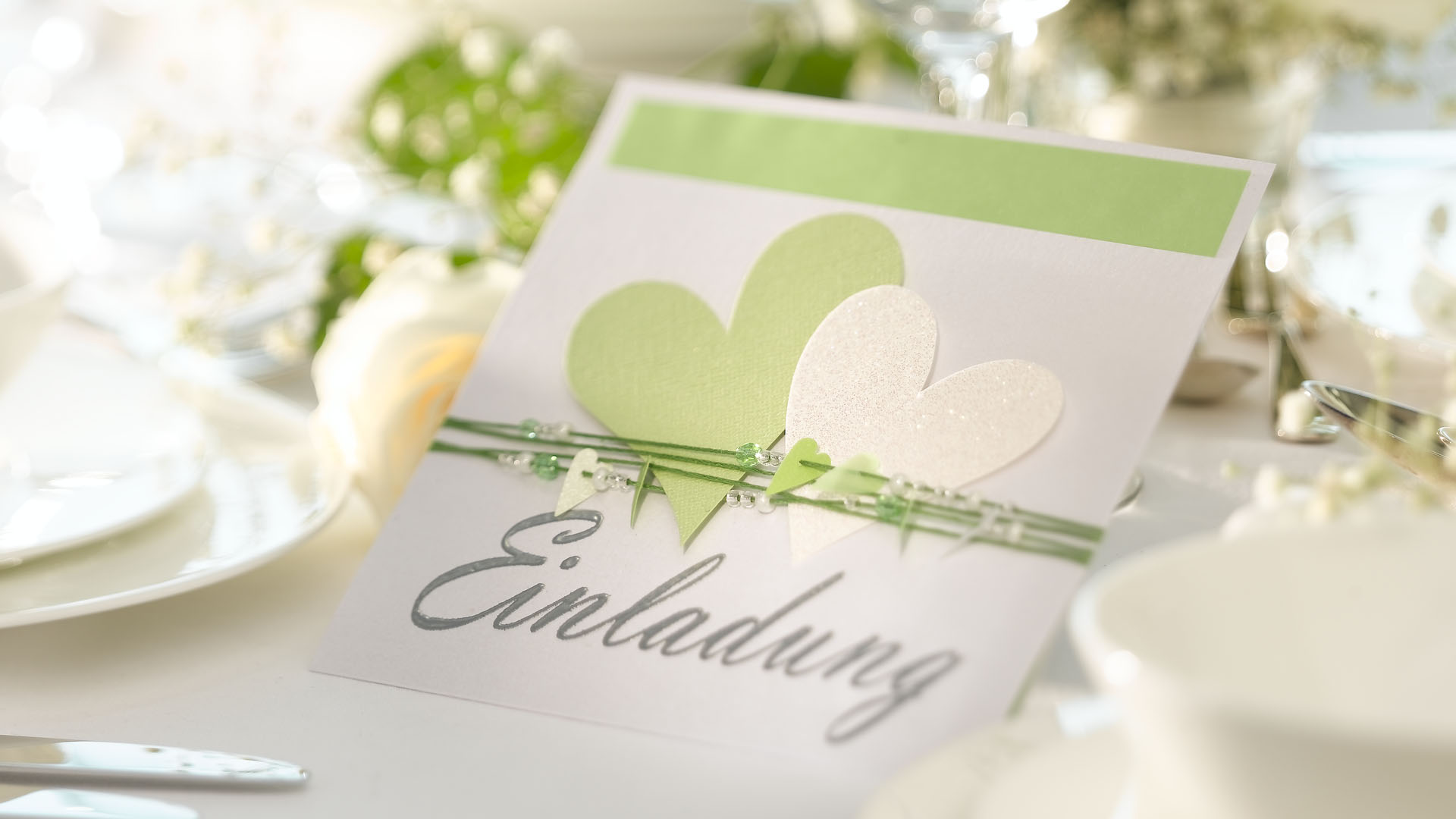 Ideen für Hochzeiten: Heartbeat in zartem Grün und Weiß | Einladungskarte mit vielen Herzen, passenden Perlen und einem großen, gestempelten Schriftzug