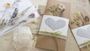 Ideen für Hochzeiten: Glaube, Liebe und Hoffnung | Einladung und Glückwunschkarte in Natur und Creme mit getrockneten Wiesenblumen, Gräsern und Spitzenborte