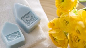 Ideen für Kommunion und Konfirmation: Alle unter einem Dach | zarte blaue Seifenstücke in Form von Häusern mit christlichem Fisch oder Schriftzug