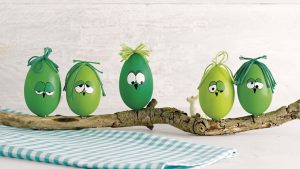 Ideen für den Frühling: Hei-ei-ei | Bemalte Eier mit lustigen Gesichtern und einem knorrigen Ast für ein witziges Dekostück in Grün