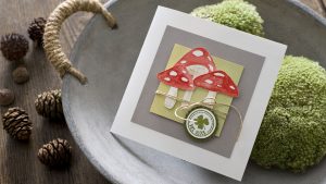 Ideen für Glückwünsche und Grußkarten: Glückspilze | Quadratische Karte in Weiß, Grau, Rot und Grün mit aquarellierten, ausdrucksstarken Glückspilzen und einem vierblättrigen Kleeblatt