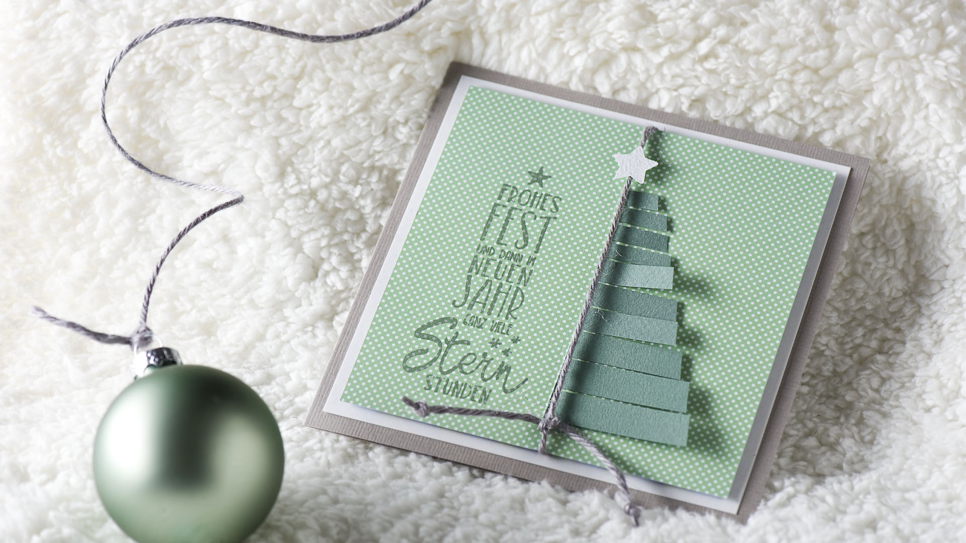 Ideen für die Weihnachtpost: Die schönsten Wünsche zum Fest | eine faszinierende quadratische Weihnachtskarte in Grau, Weiß und zartem Salbeigrün mit einem Tannenbaum aus Papierstreifen und einen gestempelten Text